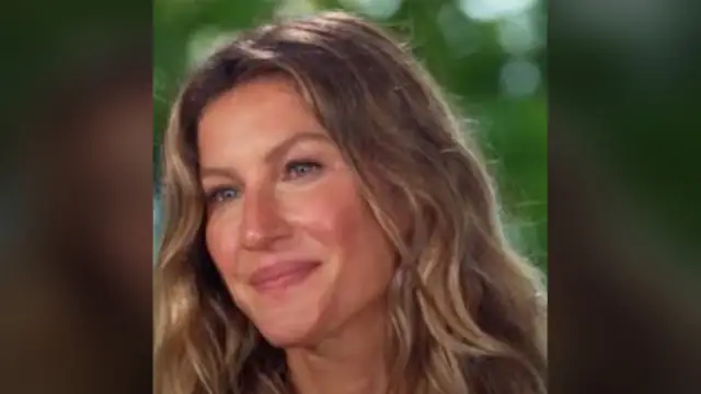 Gisele Bündchen smiling with long wavy hair against a leafy green background
