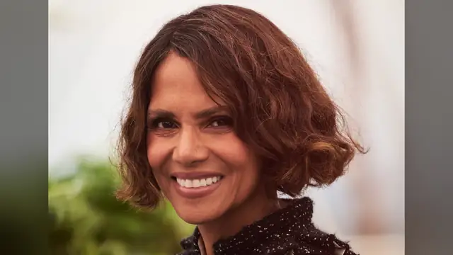 Halle Berry smiling brightly with her curly brown bob at a film festival photo call