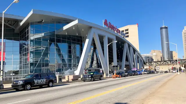 The glass and steel entrance of State Farm Arena, home of the Atlanta Hawks, on a sunny day in downtown Atlanta