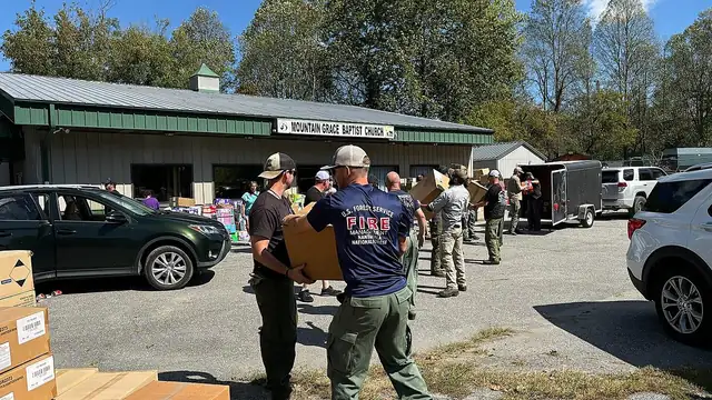 Volunteers and Forest Service workers unload relief supplies outside a church in Marshall, North Carolina, after Hurricane Helene