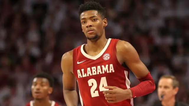 Brandon Miller in a red Alabama No. 24 jersey jogs up the court during a February 2023 college game