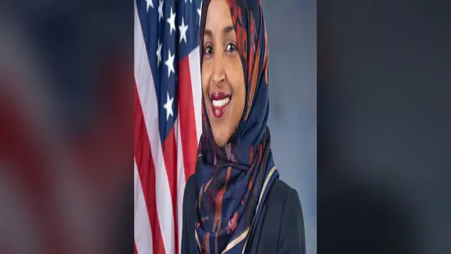 Rep. Ilhan Omar in a navy blazer and patterned hijab smiling for her official House portrait