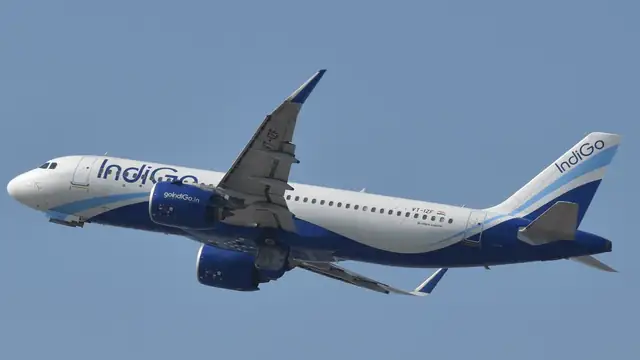 An IndiGo Airbus A320neo climbing against a clear blue sky