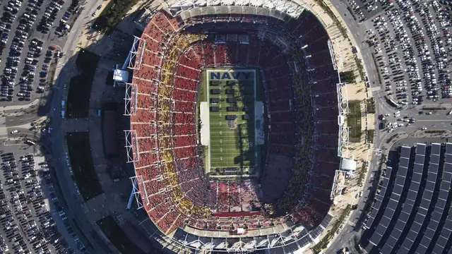 Aerial view of FedEx Field in Landover Maryland with red seats packed around a green football field