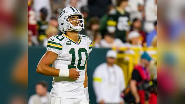 Jordan Love in a white Green Bay Packers No. 10 jersey and helmet on the field at Lambeau Field