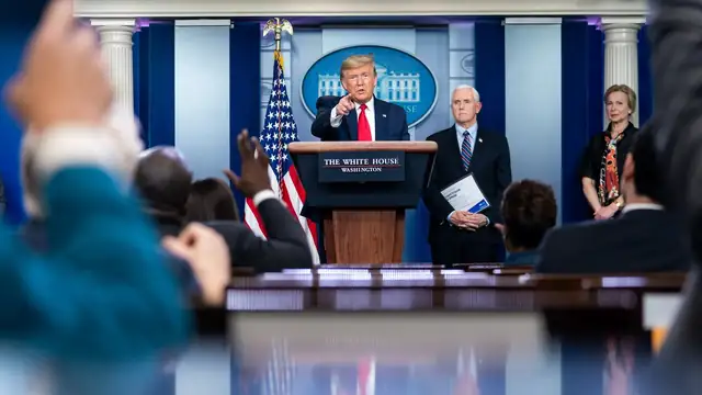 President Donald Trump points toward reporters from the lectern in the White House press briefing room