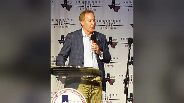 Ken Paxton speaking into a microphone at a podium during a Texas political rally