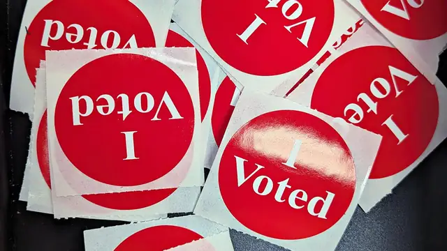 A pile of red and white I Voted stickers