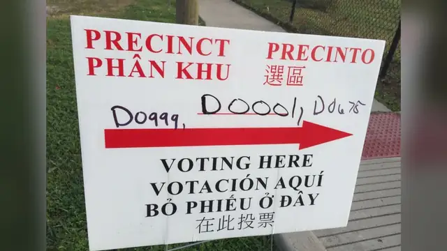 A white polling place sign with a red arrow reads Precinct and Voting Here in English and Spanish plus Vietnamese and Chinese in Harris County Texas