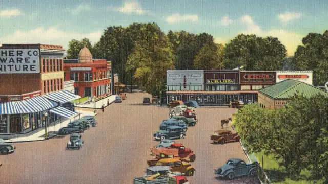 Vintage postcard view of shops and rows of parked cars around the public square in Lexington, Mississippi