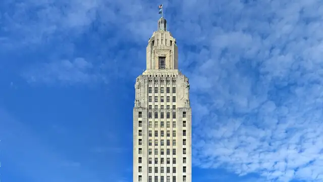 The art deco crown of the Louisiana State Capitol tower in Baton Rouge against a blue sky