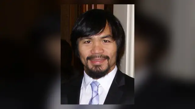 Manny Pacquiao smiling in a dark suit white shirt and light tie