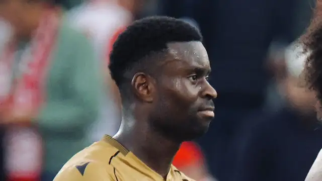 Marc Guéhi in a gold Crystal Palace away shirt looks on during a match day in 2025