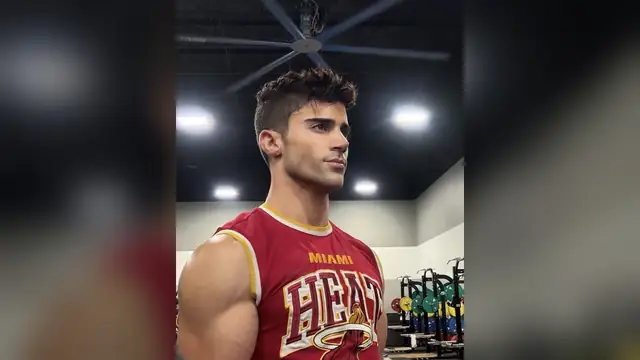 Max Ehrich in a red basketball jersey at a gym