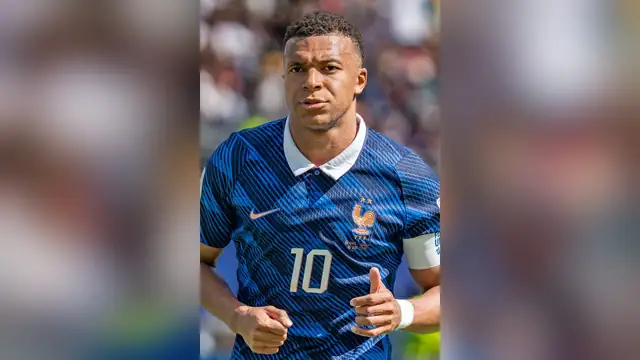 Kylian Mbappé in a blue No. 10 France jersey giving a thumbs-up