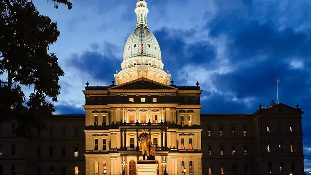 The Michigan State Capitol dome in Lansing against a blue sky