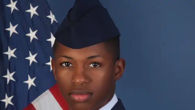 Official Air Force portrait of Senior Airman Roger Fortson in a dress uniform and cap in front of an American flag