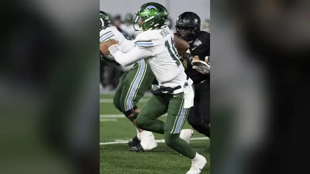 Quarterback Darian Mensah in a white Tulane jersey and green helmet drops back to pass during the 2024 AAC championship game