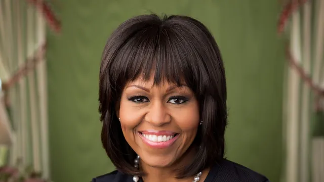 Official White House portrait of Michelle Obama smiling in a formal setting with a soft green background