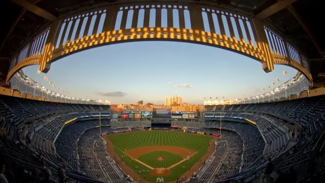 A fisheye view of Yankee Stadium at dusk with the crowd and the infield below