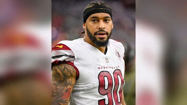 Montez Sweat in a white Washington No. 90 jersey and a black headband before a game