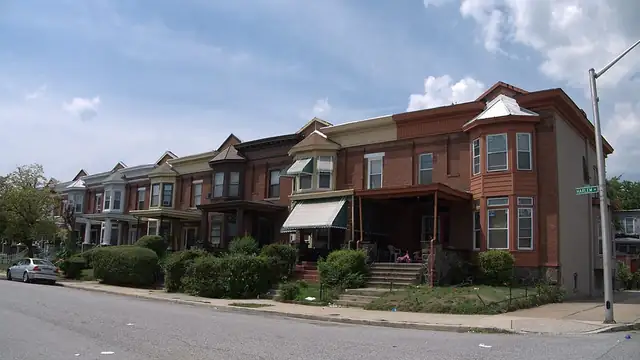 Brick rowhouses with front porches along a residential street