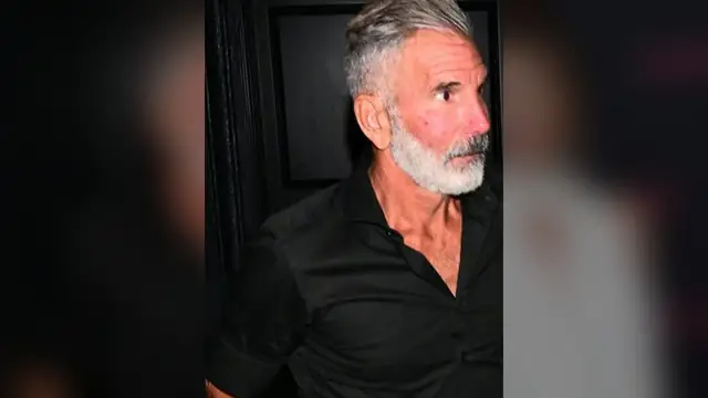 Mossimo Giannulli with gray hair and a white beard in a black shirt