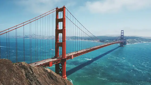 Aerial view of the Golden Gate Bridge and San Francisco Bay under a bright sky