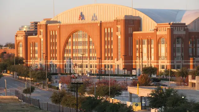 The brick and glass American Airlines Center arena in Dallas glows in late afternoon sunlight