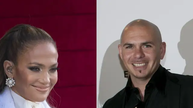 Jennifer Lopez smiling in a white coat beside Pitbull smiling in a black shirt and jacket