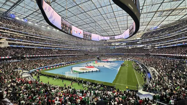 A wide view inside SoFi Stadium in Inglewood with its oval video board hanging above the field