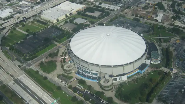 Aerial view of the white dome of Tropicana Field in St. Petersburg surrounded by parking lots and highways