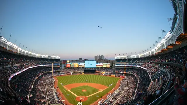 Yankee Stadium full of fans on a clear evening with the infield and outfield in view