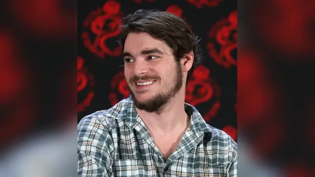 RJ Mitte smiling in a plaid shirt at a 2024 fan convention