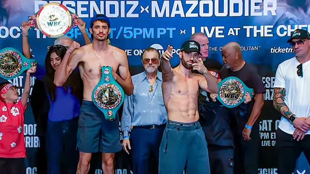 Sebastian Fundora and Ermal Hadribeaj stand shirtless in front of a fight banner holding up WBC belts at the official weigh-in in Las Vegas