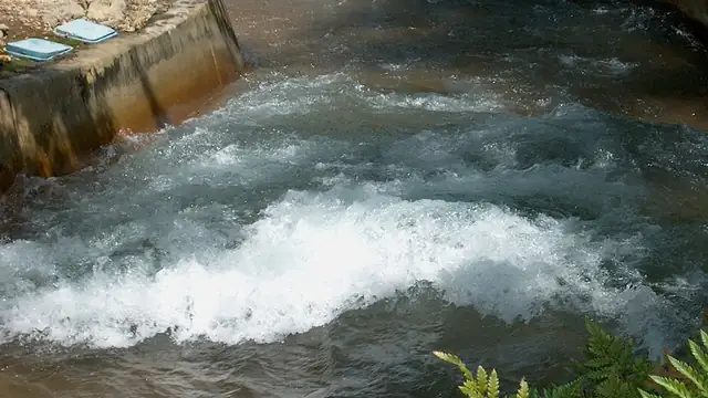 Whitewater churning through the concrete channel of a river rapids raft ride