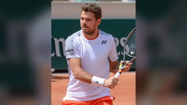 Stan Wawrinka in a white shirt lining up a backhand on a clay court