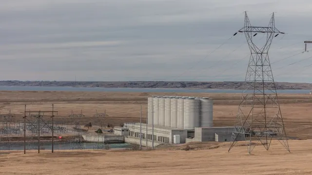 Oahe Dam and power plant on the Missouri River with Lake Oahe stretching behind concrete surge tanks and power lines