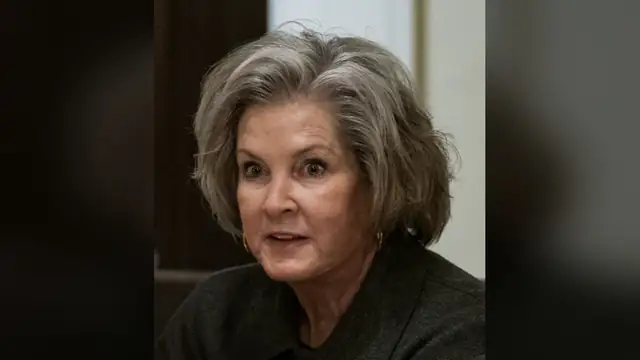 White House chief of staff Susie Wiles with silver hair in a dark gray jacket speaking at a meeting