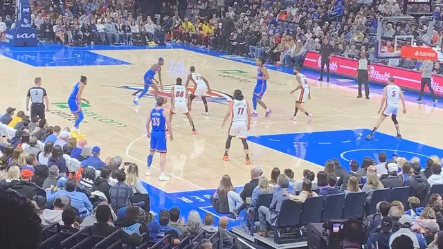 Oklahoma City Thunder players in blue home uniforms line up against the Miami Heat on the court in front of a packed arena