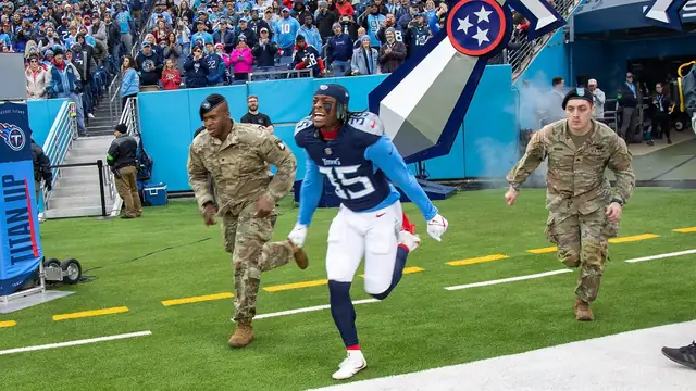 Tennessee Titans players run onto the field with Fort Campbell soldiers during a Salute to Service game at Nissan Stadium