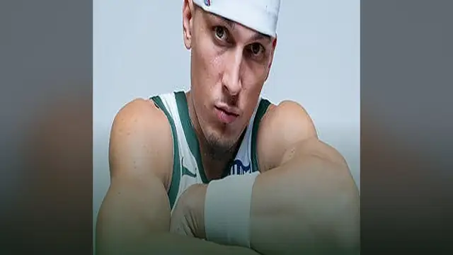 Tyler Herro in a white Bucks jersey and headband looking at the camera with his arms folded
