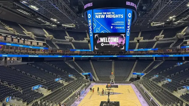 The court and seating bowl inside Chase Center in San Francisco with the scoreboard lit above