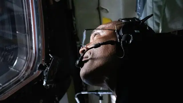 NASA astronaut Victor Glover looking out an Orion capsule window during the Artemis II flight around the moon