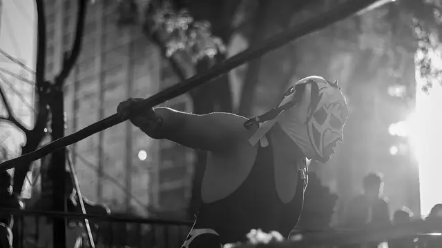 Masked luchadores battling in a wrestling ring