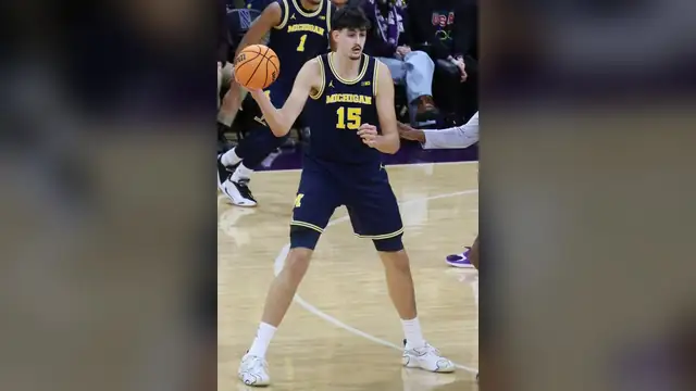 Aday Mara in a navy Michigan uniform holds the ball during a February 2026 game at Northwestern
