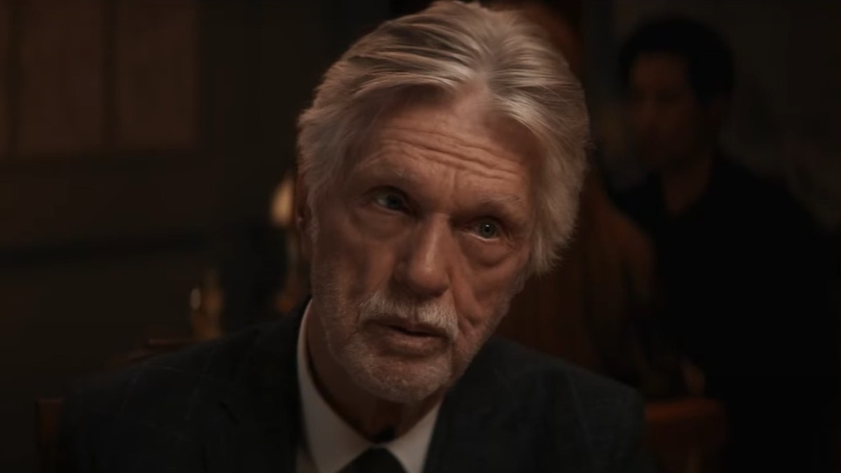 Tom Skerritt with silver hair in a dark suit during a dinner scene from East of the Mountains