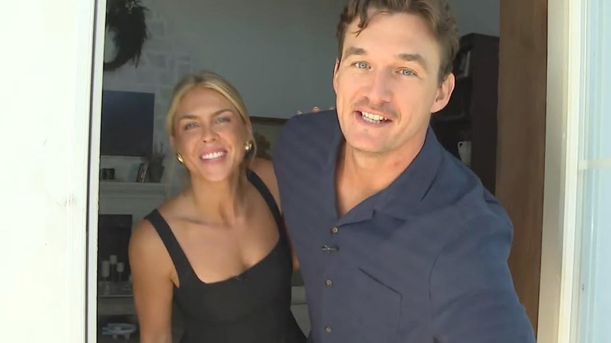 Tyler Cameron and Tate Madden smiling together in the doorway of their Florida home