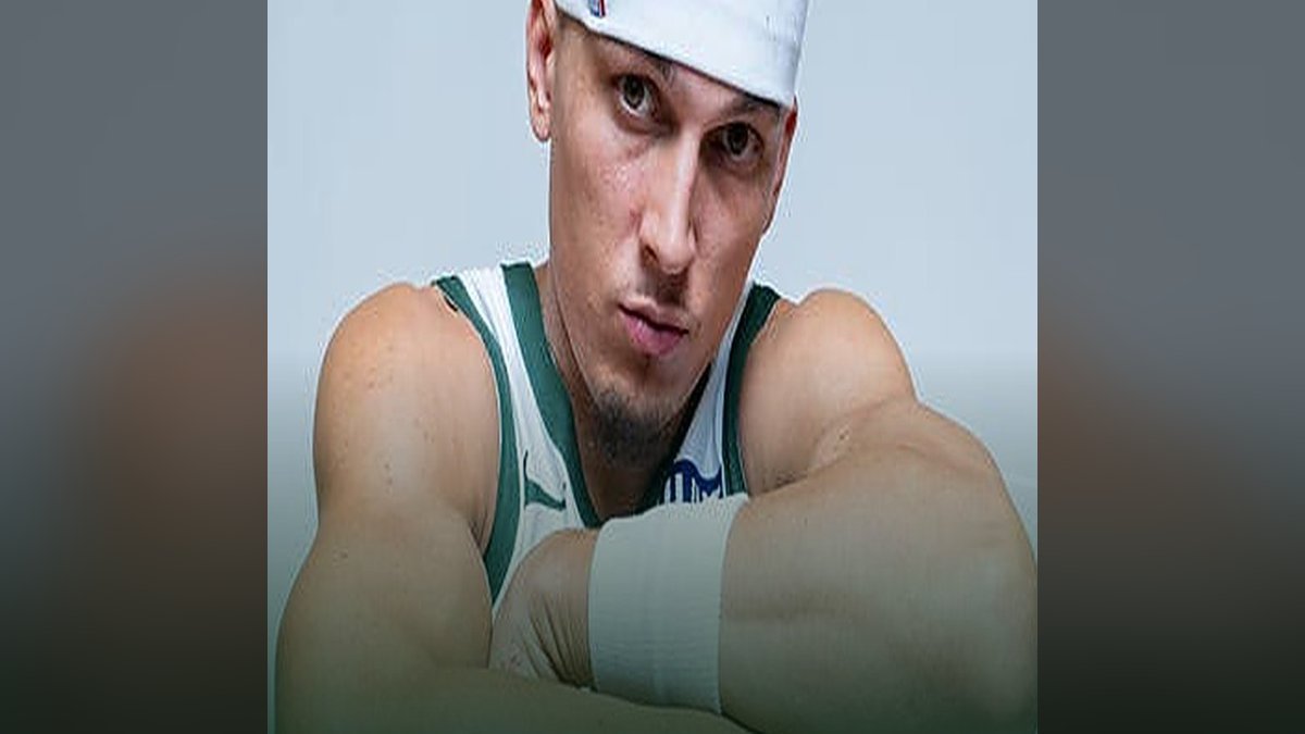 Tyler Herro in a white Bucks jersey and headband looking at the camera with his arms folded