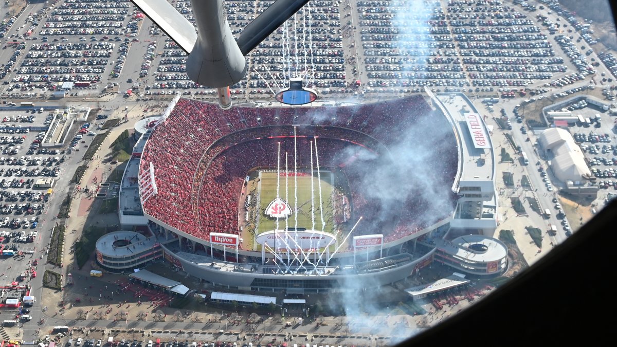 A KC-135 refueling boom hangs over an aerial view of Arrowhead Stadium in Kansas City packed with fans in red during a January 2023 Chiefs game